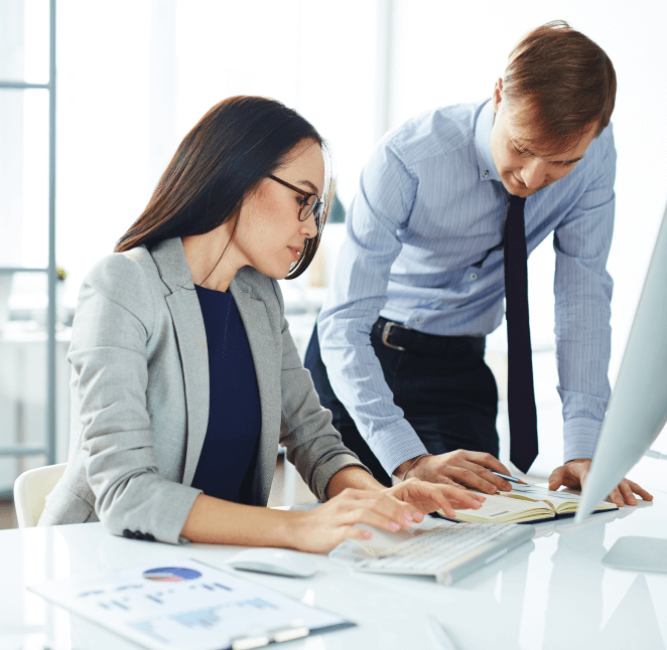 Colleagues are consulting with each other, with documents laid out in front of them.